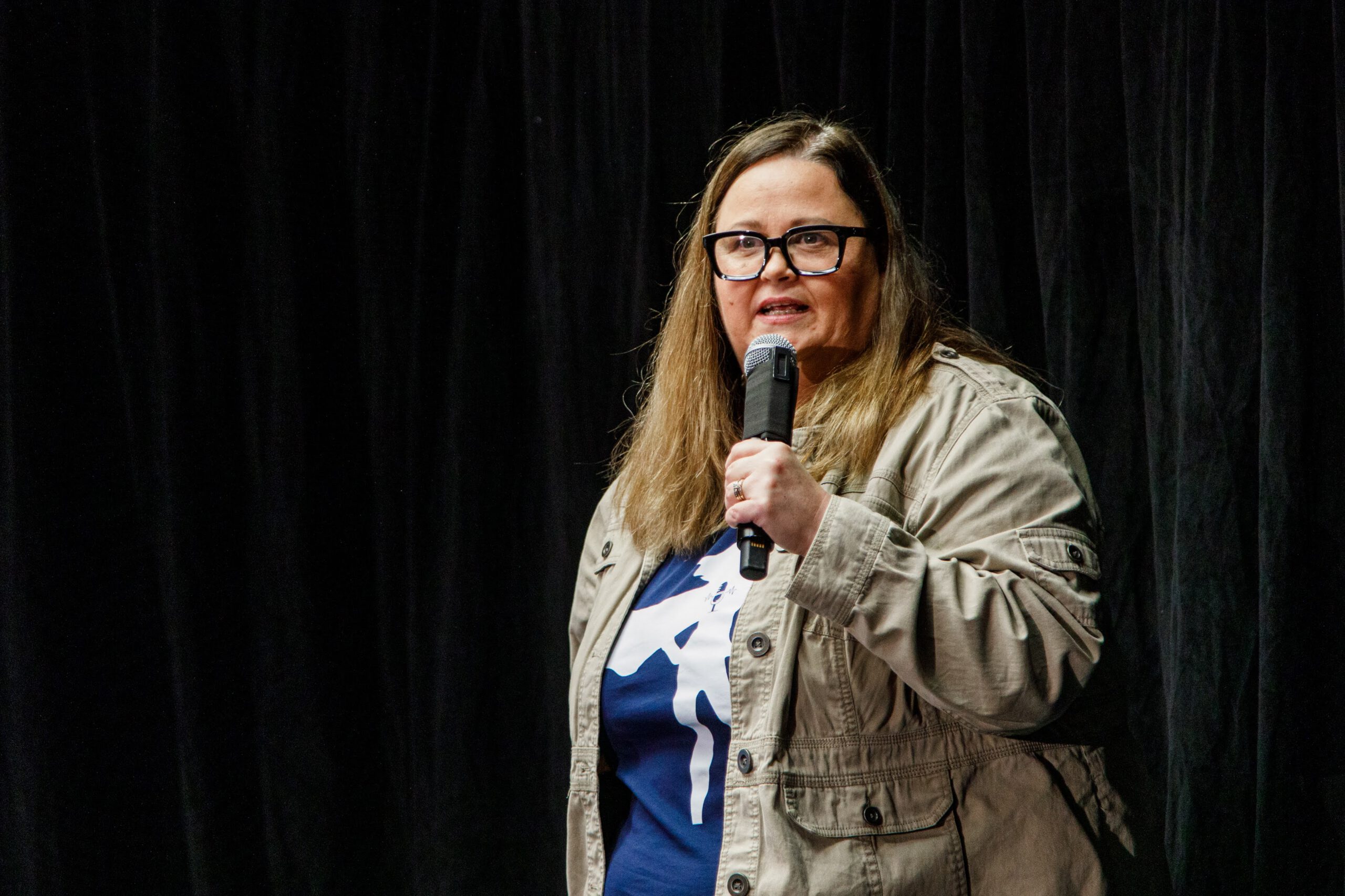 Josie holding a microphone at a keynote speaking event