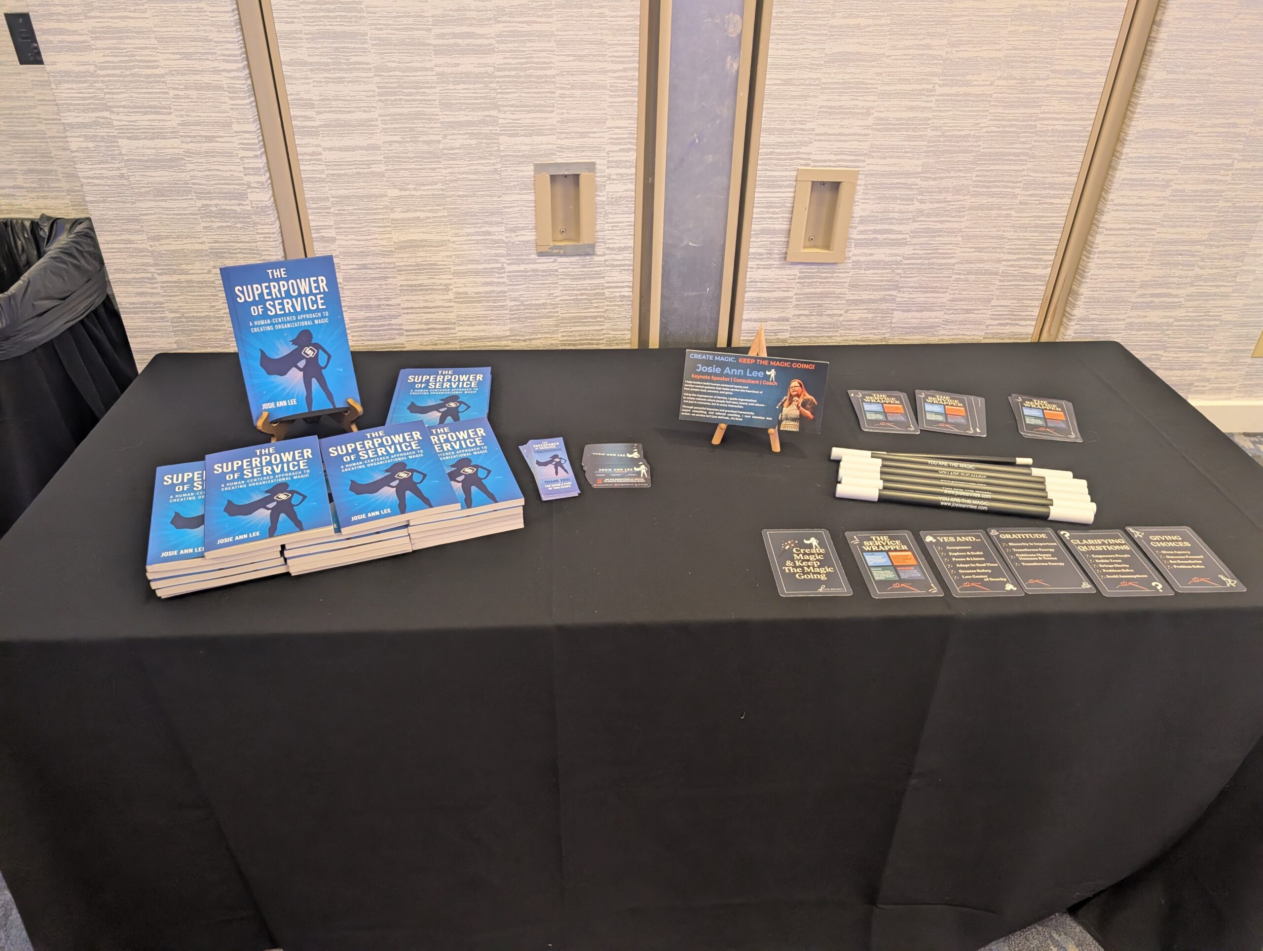 A table with many copies of Josie's book The Superpower of Service laid out